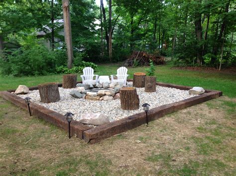 Fire pit - rail road ties, river rock and a ring. Simple and cheap ...