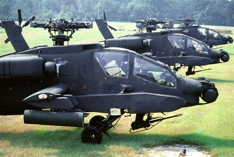 Three AH-64A Apache helicopters, their main rotor blades having been ...