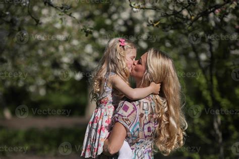 daughter kisses mom in the garnde 11339302 Stock Photo at Vecteezy