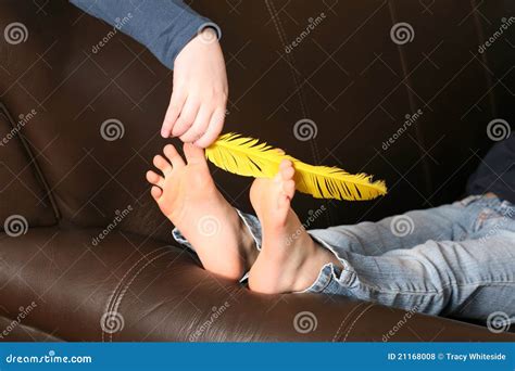 Feather tickling bare feet stock photo. Image of hand - 21168008