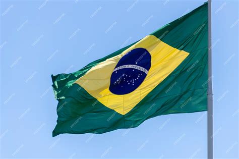 Premium Photo | Flag of brazil fluttering in the blue sky. order and progress, in portuguese ...