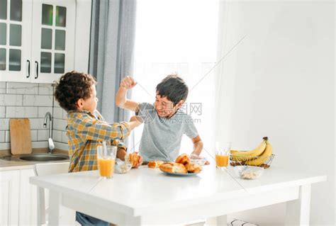 两个兄弟姊妹真正的兄弟们在早餐桌上打架在家里高清图片下载-正版图片503989545-摄图网
