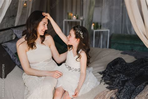 Mother and daughter cuddling on a bed in a kids room