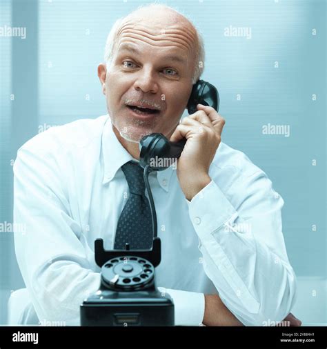 Mature businessman is caught off guard by a phone call, his surprised ...