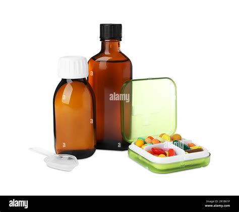 Bottles of syrups, plastic spoon with pills on white background. Cough ...