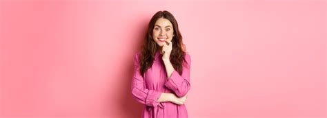 Linda garota animada sorrindo mordendo o dedo e olhando com cara ...