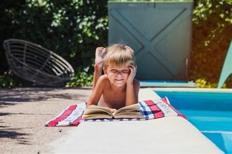Little boy lying on towel near pool | Free Photo