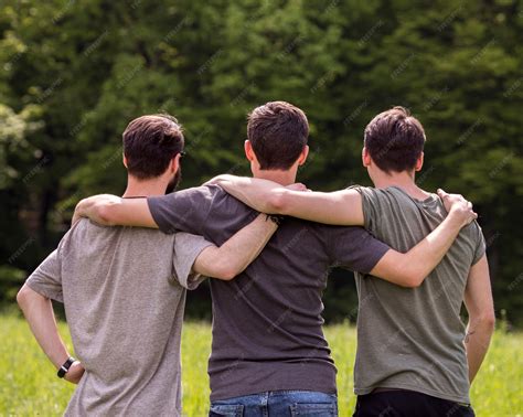 Premium Photo | Friends standing on glade with hands on each other ...