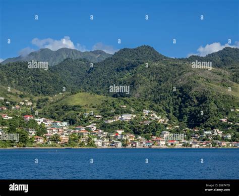 A view from the sea of the lush mountains surrounding the capital city of Roseau, on the west ...