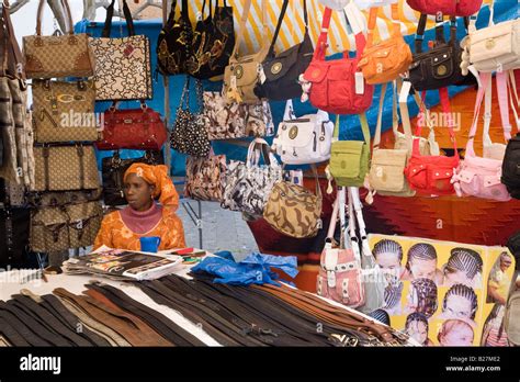 African woman selling handbags and leather belts on market stall Stock ...