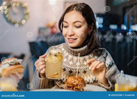 Woman at the Bar, Have a Burger and Watching a Hot Alcoholic Drink ...