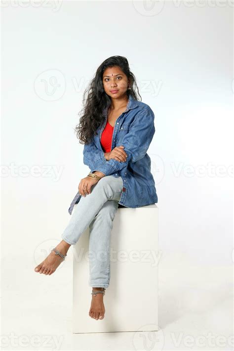 Young attractive asian Indian woman sit pose on white background look ...
