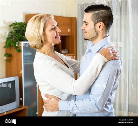 Cheerful mature woman and young boyfriend dancing indoors Stock Photo ...