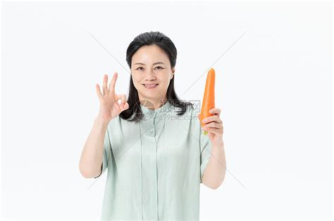 中年女性手拿胡萝卜高清图片下载-正版图片501378618-摄图网