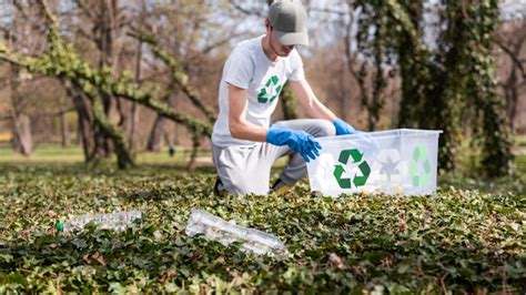 Man collecting plastic garbage in a polluted park | Free Photo
