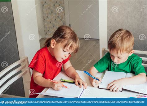 Children Sit at the Table and Write in Notebooks Stock Image - Image of ...