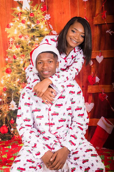 Download A Couple In Christmas Pajamas Posing For A Photo | Wallpapers.com