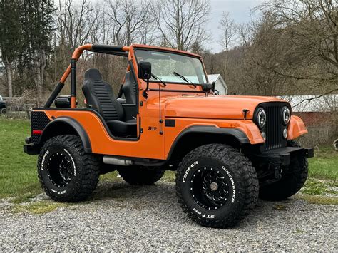 Orange Jeep Wrangler Parked on Gravel