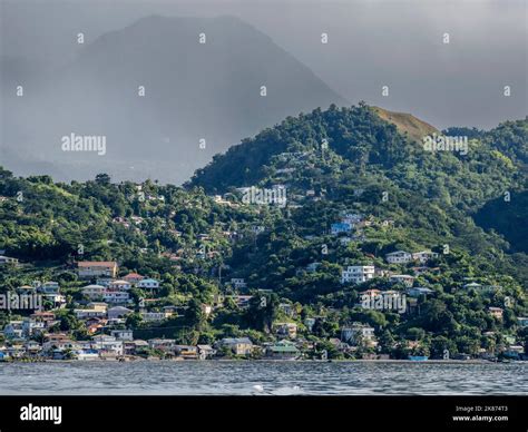 A view from the sea of the lush mountains surrounding the capital city of Roseau, on the west ...