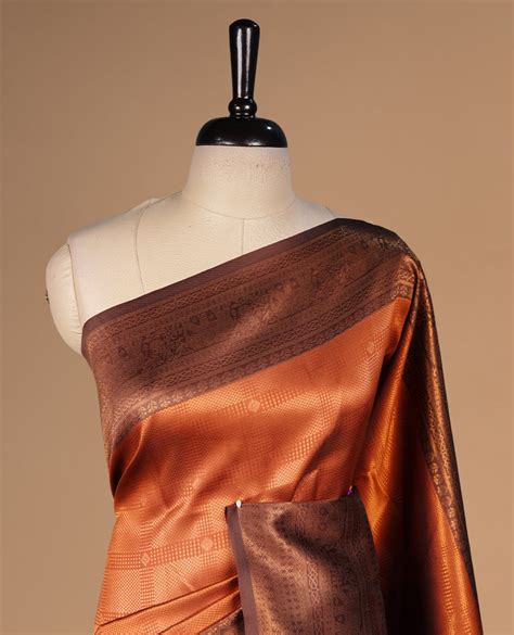 Burnt orange colour silk saree featuring gold zari check and motifs on