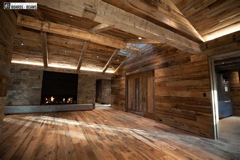 Reclaimed hand hewn beams tower over a mixed oak floor while wired ...