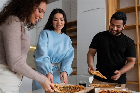 Group of friends eating pizza at home together | Free Photo