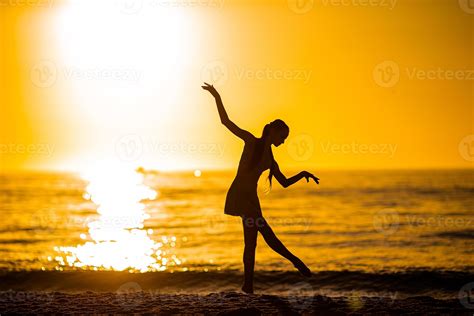 Silhouette of the beautiful girl dancing on the beach at sunset 18043870 Stock Photo at Vecteezy