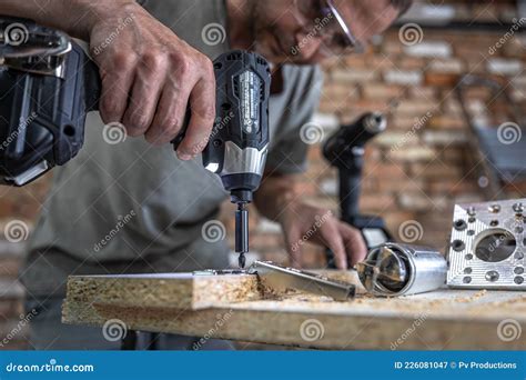 A Man is Screwing in a Screw, a Self-tapping for Wood Stock Image ...