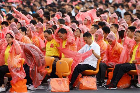 Military aircraft fly in formation past a red flag at the event marking ...