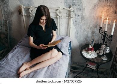 Woman reading in The Ritz-Carlton bed at a hotel