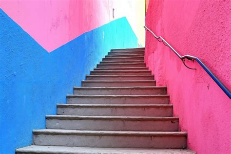 A set of stairs leading up to a pink and blue wall | Premium AI ...