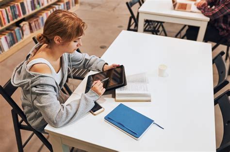 Student learning in university library young making notes using ...