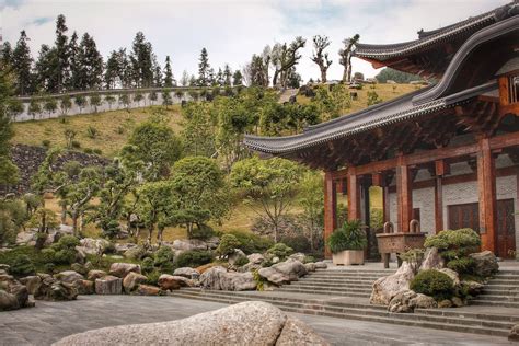 Photo of an elaborate Chinese temple with hedges in front.