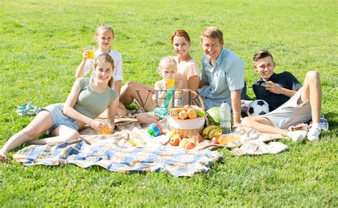 活跃的大家庭在公园的绿色草坪上野餐照片摄影图片_ID:134832368-Veer图库
