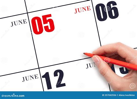 A Hand Holding a Red Pen and Pointing on the Calendar Date June 5. Red ...