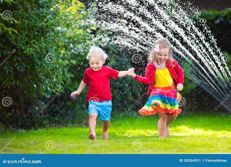 Kids Playing with Garden Sprinkler Stock Image - Image of lawn, people ...