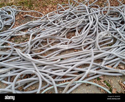 Corrugated pipes for electrical wiring lie in heap on the ground Stock ...