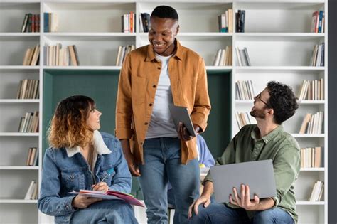 Jovens colegas estudando de notebook e laptop durante a sessão de ...