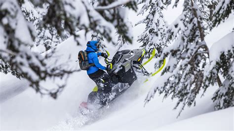 Rider riding up a snowy mountain on the 2027 Ski-Doo Summit