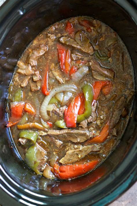 A bowl of slow cooker pepper steak, served over white rice
