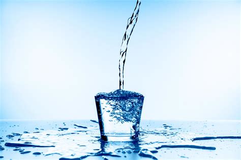 Pouring water into glass on blue background 4280188 Stock Photo at Vecteezy