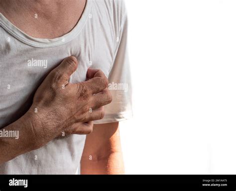 Asian young man suffering from left sided chest pain. Chest pain can be caused by heart attack ...