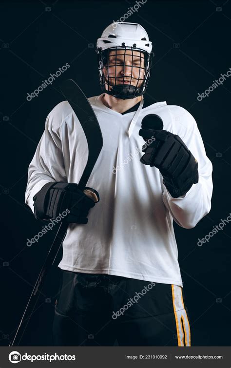 Handsome hockey player. Smiling at camera isolated on black background ...
