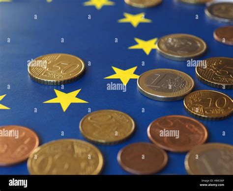 Euro coins (EUR), currency of European Union over flag of Europe Stock Photo - Alamy