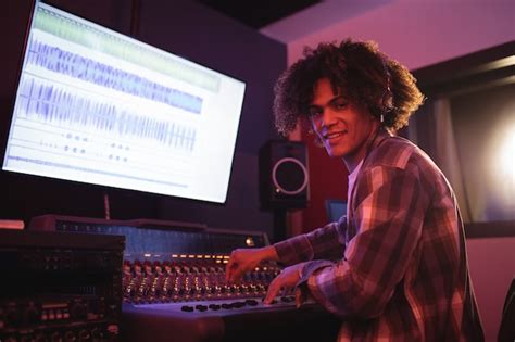 Portrait of male audio engineer using sound mixer | Free Photo