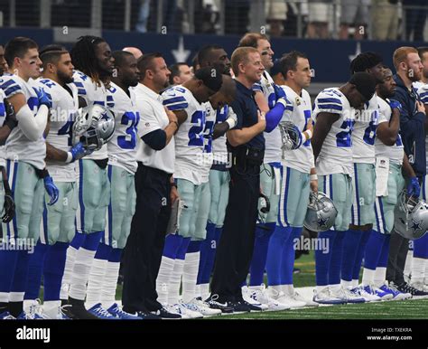 Dallas Cowboys, including head coach Jason Garrett, center, stand for ...