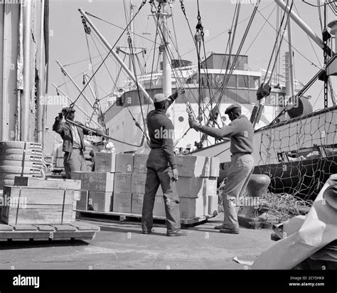 1850s 1960s THREE ANONYMOUS AFRICAN-AMERICAN DOCK WORKERS LONGSHOREMEN LOADING A CARGO SHIP IN ...