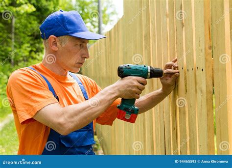 Handyman Constructing the Wooden Fence Stock Image - Image of overalls ...