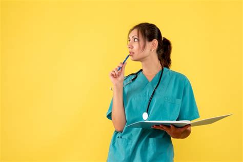 Front view female doctor in medical shirt holding notes on yellow ...