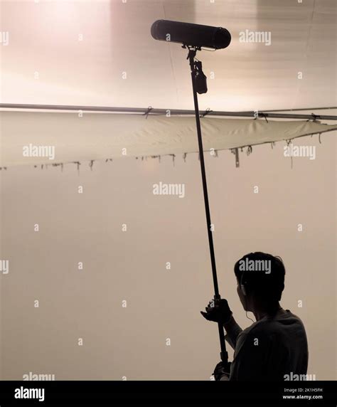 Boom Microphone for sound recording in film industry. Sound boom operator recording sound by ...